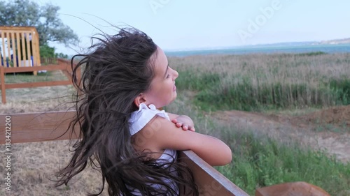 A thoughtful young girl with her hair blowing in the wind