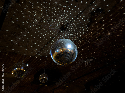 Disco balls on ceiling of nightclub. Concept for dancing and relaxation in nightclub. Silver dance ball with adjacent sections for beautiful lighting of dance floor