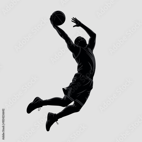 Silhouette of a basketball player dunking the ball against a plain background