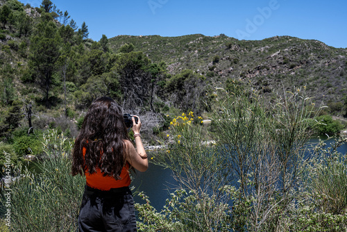 Young woman takes a photograph of the San Jerónimo Dam in La Cumbre, Córdoba Province, Argentina.