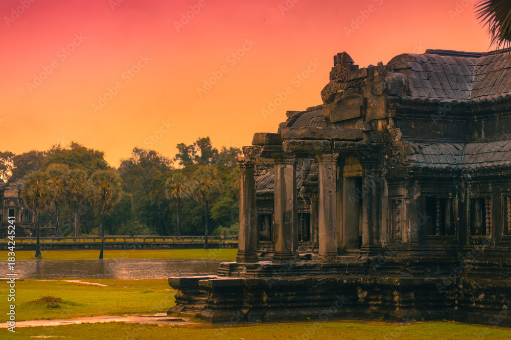 Naklejka premium Sunset Over Ancient Angkor Wat Temple With Warm Sky And Historic Stonework