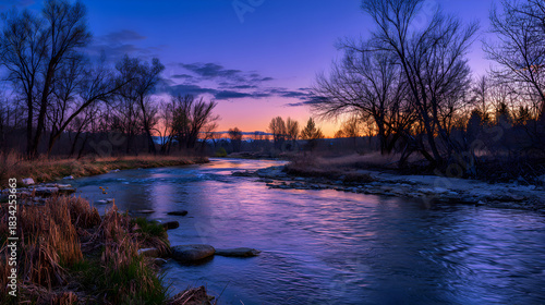 Scenic river flowing through trees at twilight with vibrant purple sky