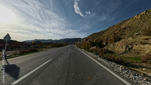 Driving along a winding asphalt mountain road. A paved road in the highlands. First-person view, filmed with an action camera without motion blur.