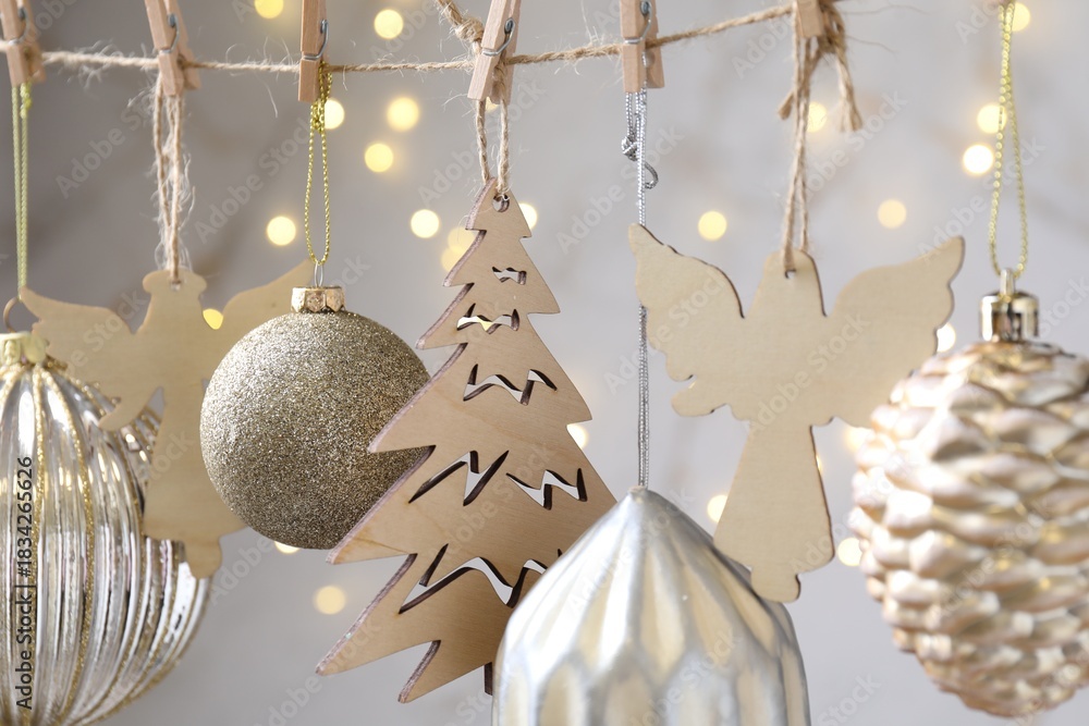 Fototapeta premium Beautiful Christmas decor hanging on string against blurred lights, closeup