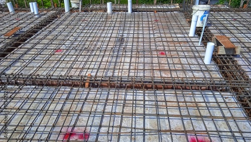 The construction of a concrete foundation using reinforcing steel prepared at the construction site.