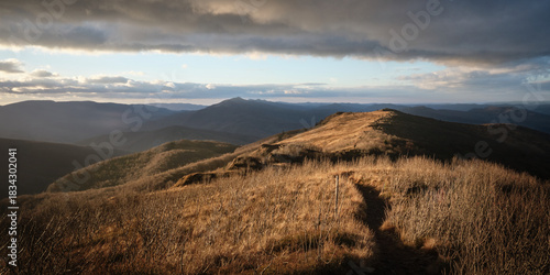 Fototapeta Naklejka Na Ścianę i Meble -  Scenic mountain ridge and hiking trail at golden hour, symbolizing journey, freedom and mindful escape into nature.