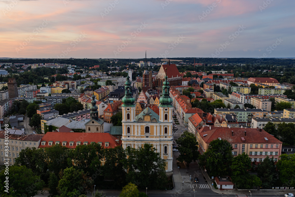 Fototapeta premium Aerial drone sunset view of Nysa historic town square and church in Opole Poland, golden hour on Renaissance baroque architecture, cobblestone market, cathedral tower, red rooftops