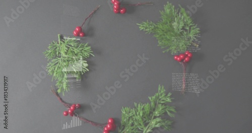 Displaying wreath of pine sprigs and glossy red berry clusters on dark gray table, with overlays