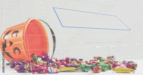 Tipping orange pumpkin bucket spilling wrapped candy on white table, with 3D grid and blue polygons
