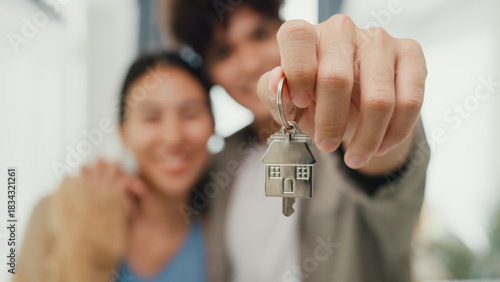 Obraz na plátně Close-up Young happy Asian sweet couple hug each other smiling looking at camera so proud show off new house keychain in living room