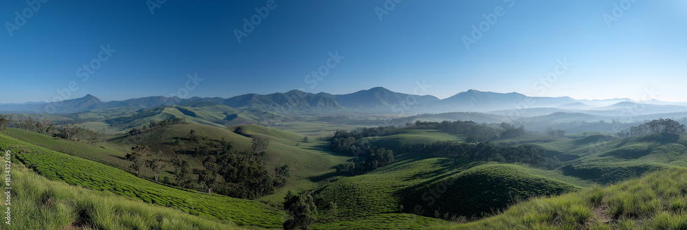 Obraz premium Expansive panoramic valley reveals layered mountain ridges under clear bright sky.