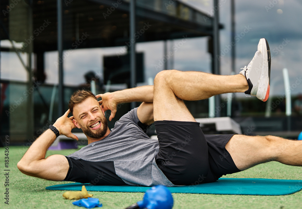 Fototapeta premium Portrait of healthy fit man doing crunches at the gym exercising in fitness club, healthy life, athlete and strength concepts