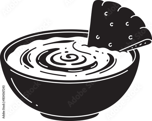 Delicious dip in a bowl with tortilla chip black and white