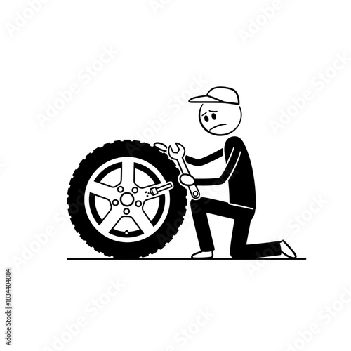 Man fixing a tire with a wrench while kneeling on the ground  