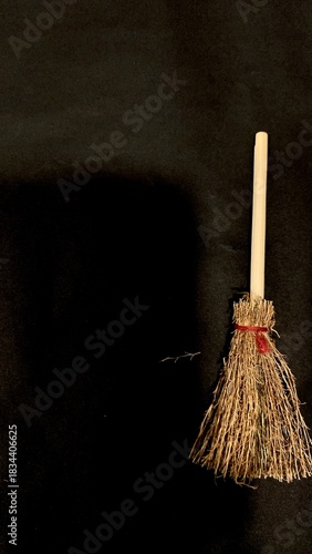 Mini witch brooms on black background, occult props, mystical composition, esoteric tools for magic and rituals