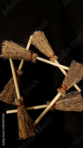 Mini witch brooms on black background, occult props, mystical composition, esoteric tools for magic and rituals