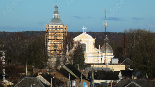 Photography Church reconstruction in a small town with wooden houses in the foreground durin