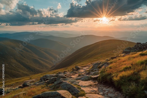 A scenic mountain landscape at sunset, with a path leading towards the golden hour