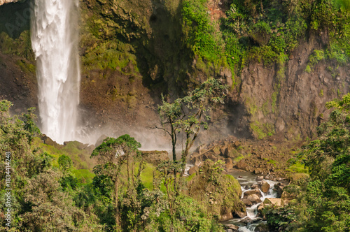 Waterfall amid the vegetation of cloud forests in the Colombian Andes, with the power of water falling between rocks and trees surrounded by the humidity of the environment.