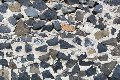 This image shows a rough old stone wall background made from various rocks and mortar, creating a textured surface perfect for rustic design.