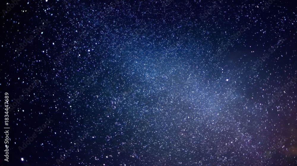 Obraz premium A breathtaking display of stars fills the night sky with specks of light. The vast backdrop of space creates a sense of wonder and tranquility in the dark evening.