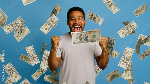 Lottery winner celebrating a jackpot as hundred-dollar bills rain down around him. Triumphant young man achieves financial freedom. Stable medium shot.