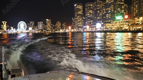 Nighttime Boat Ride in Hong Kong City Lights and Water Reflections.