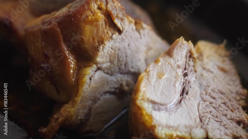 macro of fork taking a cut appetizing prepared piece of meat from the baking sheet, consumption of fatty meat, macro pork meat dishes