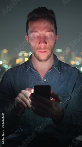 Wallpaper Mural individual engrossed in digital display, person gazing at phone screen with city lights blurred background Torontodigital.ca