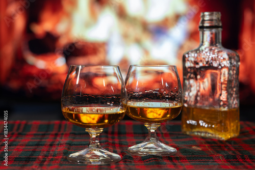 Deux verres d'alcool devant feu foyer, soir, horizontal