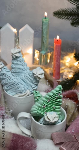 Cozy christmas meringue trees in mugs with burning candles