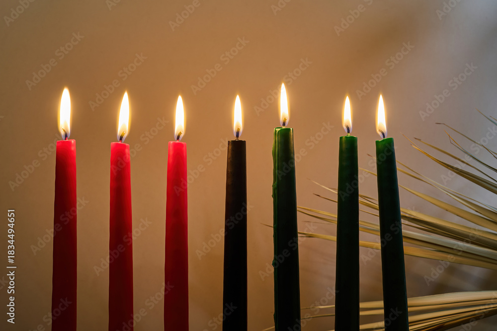 Fototapeta premium Kwanzaa Candles. Lit Kwanzaa candles in red, black, and green symbolize unity and celebration.