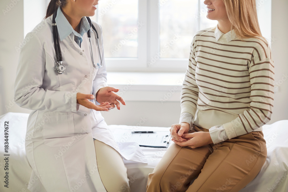 Fototapeta premium Close up shot of a patient engaging in a conversation with a doctor or nurse during a medical consultation at a hospital or clinic. Healthcare, communication, and the delivery of medical services.
