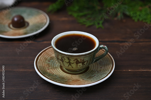 a cup of black coffee on a wooden background