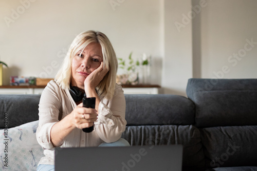 Konstfotografi Mature woman feeling bored watching television while working from home