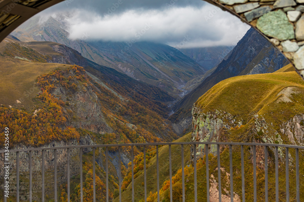 Obraz premium Framed View Of Autumn Mountain Valley Through Stone Arch In Georgia