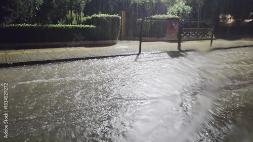 Storm Byron in Athens Greece, shot through car window blurred by falling water. Heavy rain causes flooding on streets. Water accumulates rapidly, affecting visibility and car traffic conditions.