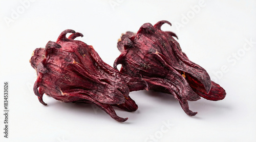 Top down view of two dried deep red hibiscus flowers isolated on a white background, often used as a natural ingredient for making healthy herbal tea or roselle beverages.