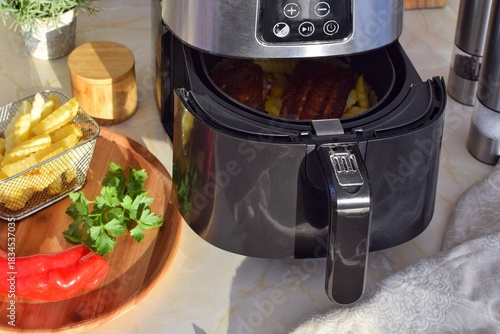 Black oil-free fryer in the kitchen.  Cooking in an air fryer without oil.Healthy food preparation