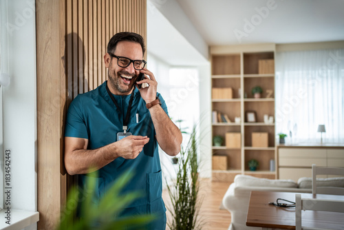 Male doctor laughing making phone call
