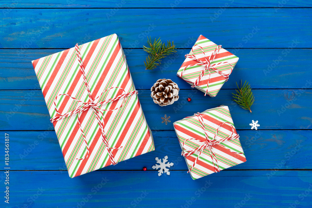 Striped Christmas gift boxes on wooden background, top view