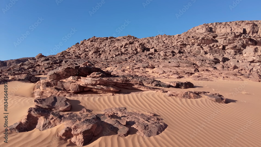 Fototapeta premium A trip to Sahara desert in Algeria. Beautiful african travel photo. Sandy landscapes, mountains, rocks, dunes, and nature. Summer vacation in arab country.