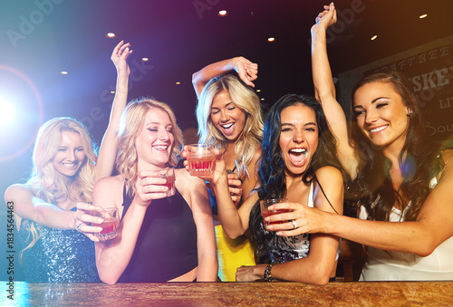 Photography Excited, laughing and girl friends with cocktails at pub for disco, celebration or fun at event together
