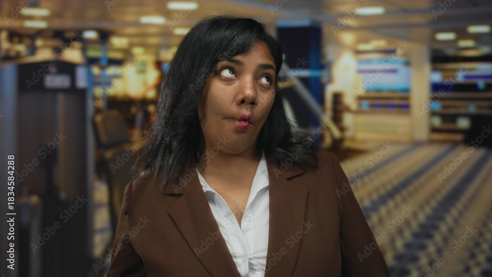 Obraz premium Woman smiles with visible lips and relaxed posture by modern weight machine in gymnasium; confidence empowerment success growth.