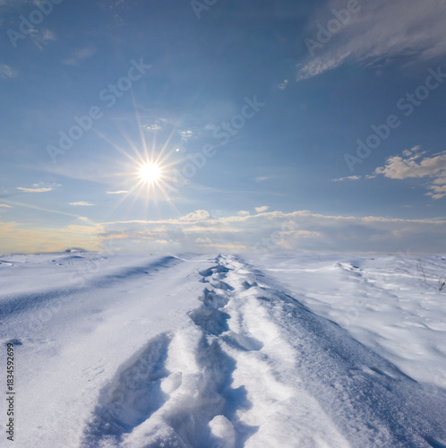 closeup snowbound plain with human track at the winter sunny day