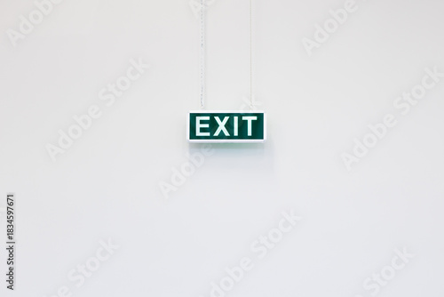 Emergency exit sign isolated on white minimalist wall. Clean and simple emergency exit sign on neutral background, ideal for safety, architecture and instruction concepts.