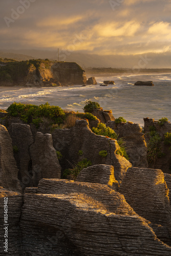 Dramatic golden hour light on stratified Pancake Rocks, Punakaiki, NZ