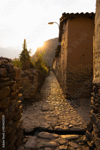 Golden sunset light on cobbled backstreet in Ollantaytambo, Peru