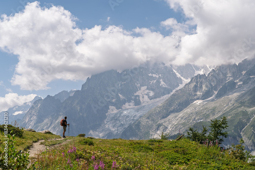Hiker admiring dramatic peaks in Italian Alps on Tour du Mont Blanc