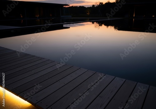 Tranquil evening waterscape with reflected sunset and wooden pier